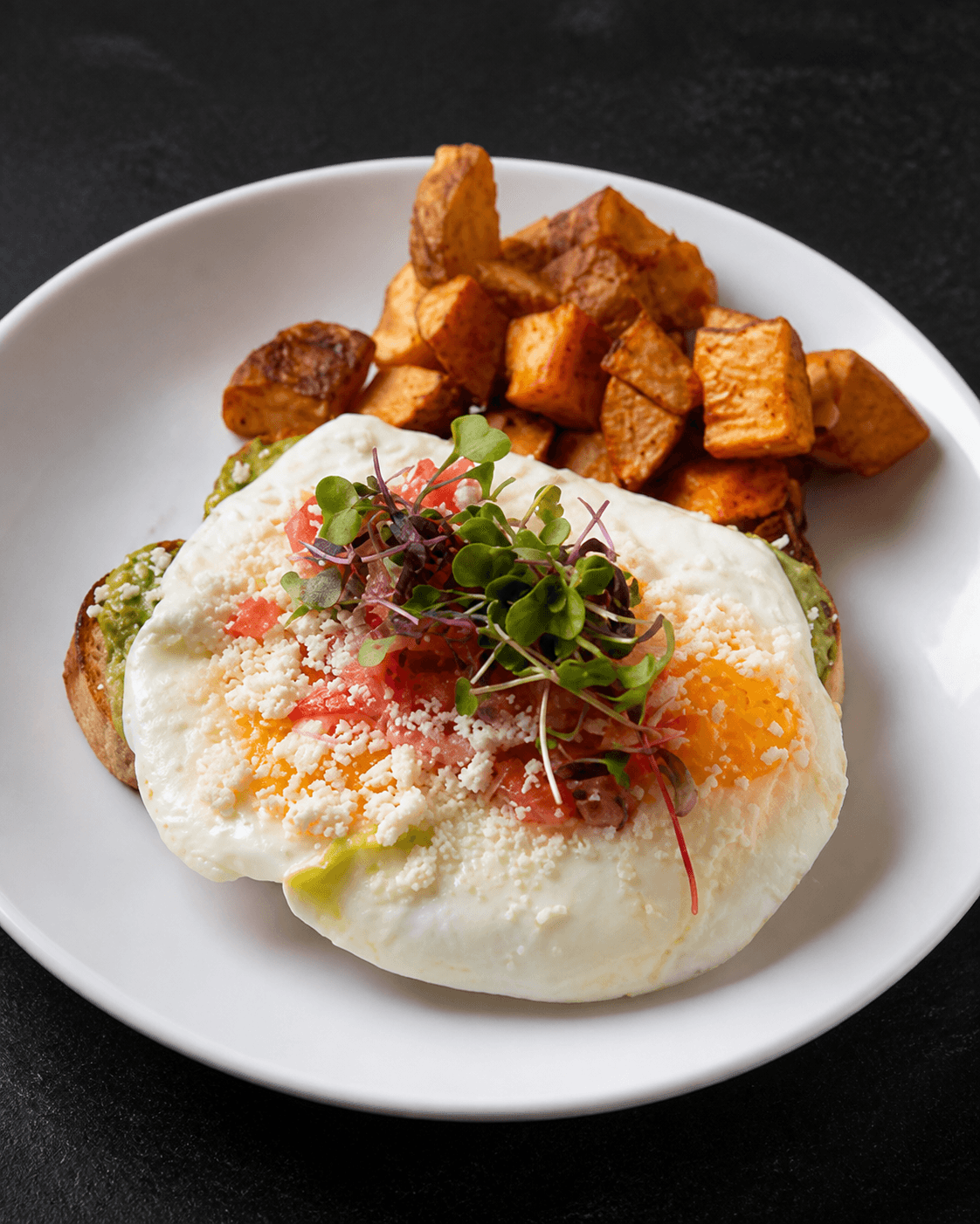 Casa Mia Bistro avocado toast with eggs, tomatoes, queso fresco, and potatoes