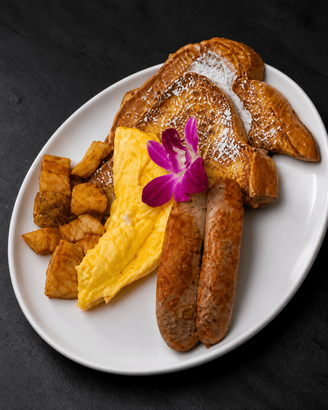 Mia's Breakfast Platter with French toast, eggs, sausage, and potatoes
