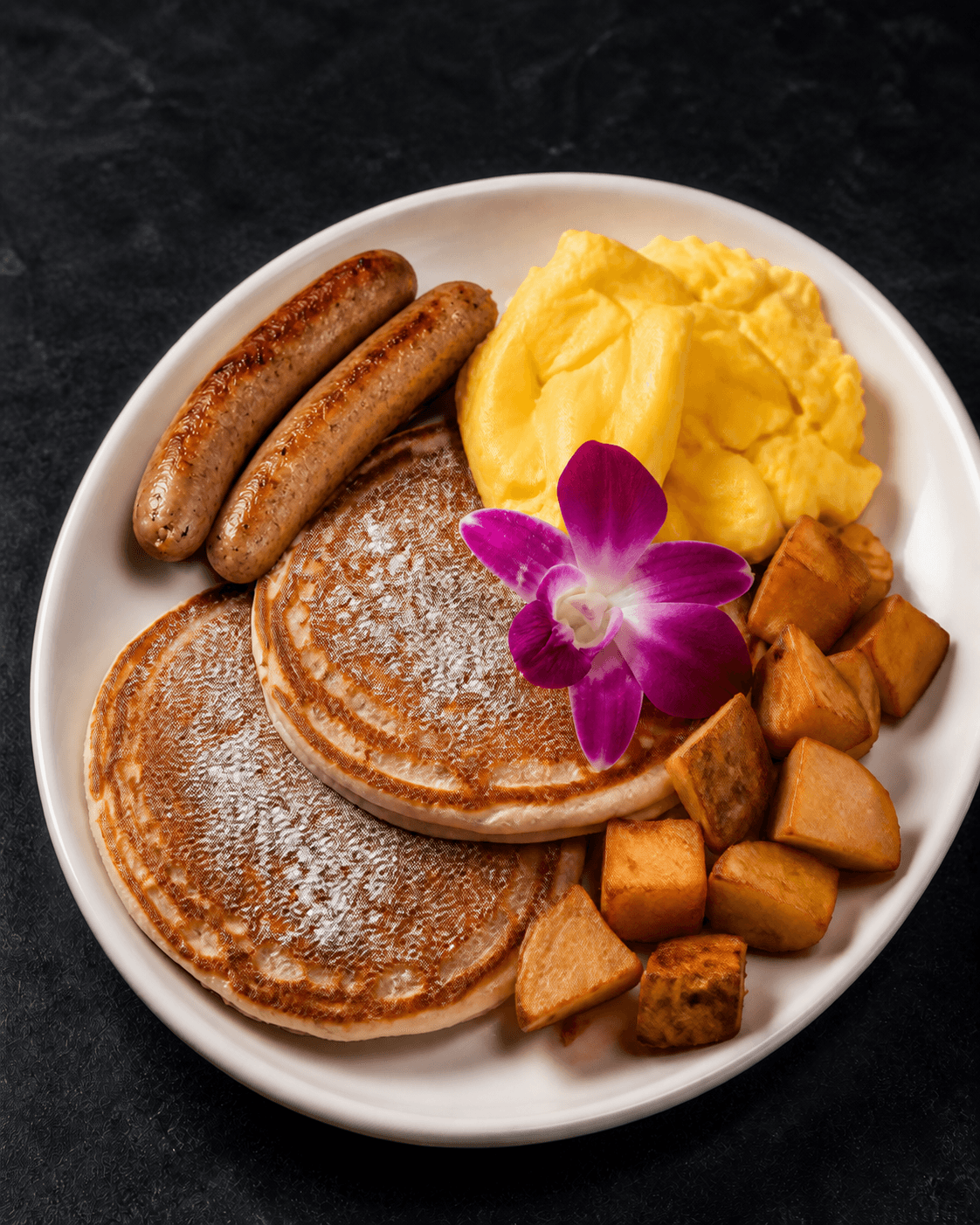 Mia's Breakfast Platter with pancakes, eggs, sausage, and potatoes